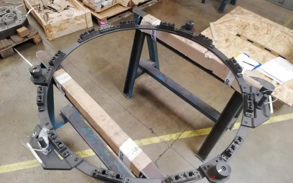Utillaje de montaje anular de acero, colocado sobre caballetes en taller.